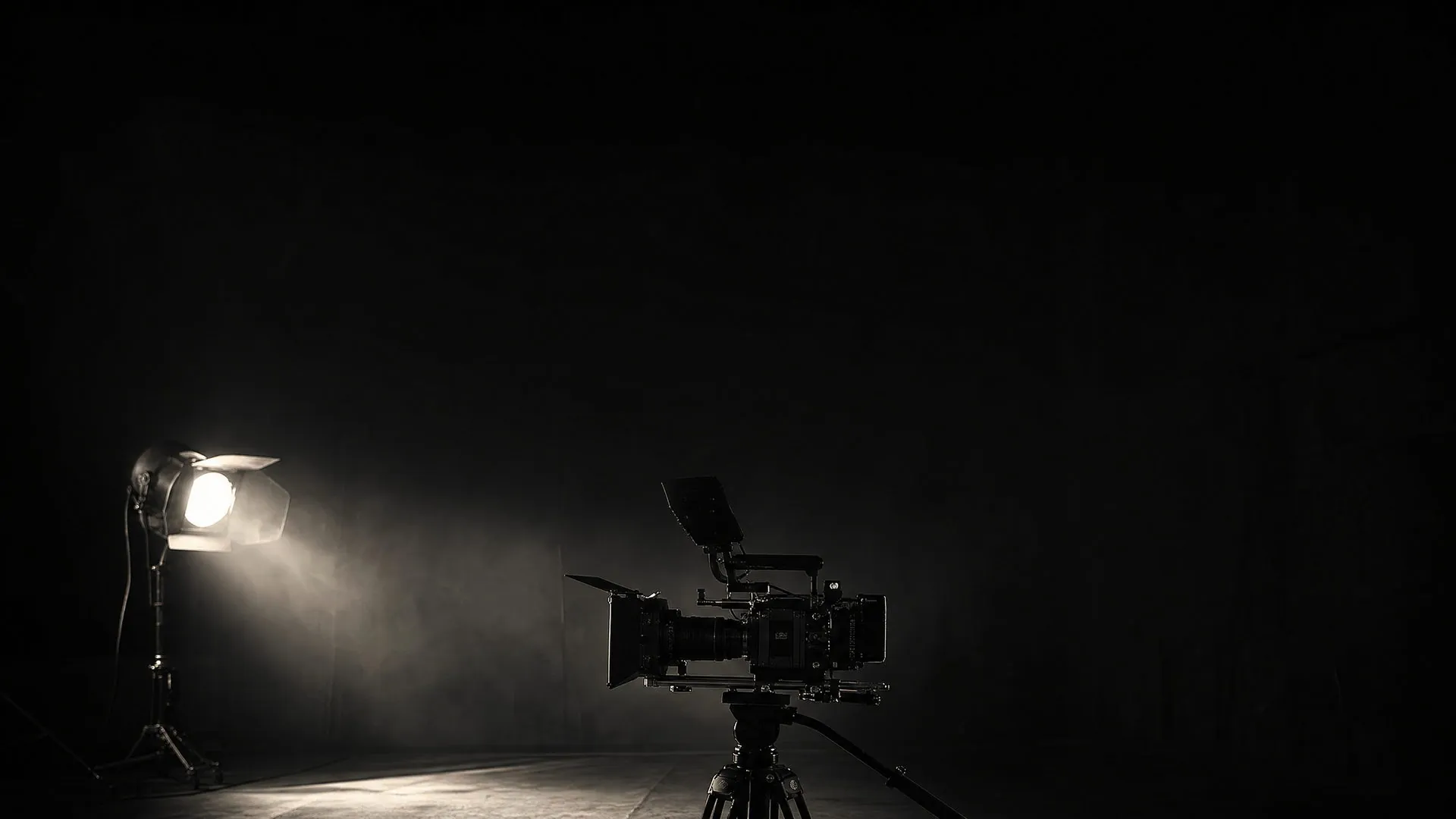 Core Media Co. brand imagery: a cinema camera on a tripod beside a single lamp on a dark stage.