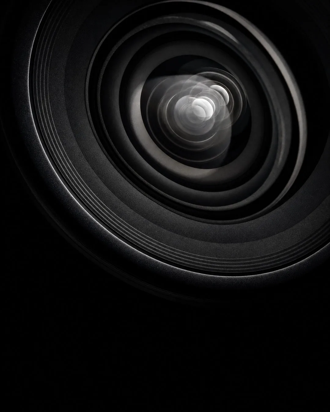 Core Media Co. brand imagery: an extreme close-up of a camera lens against a black background.