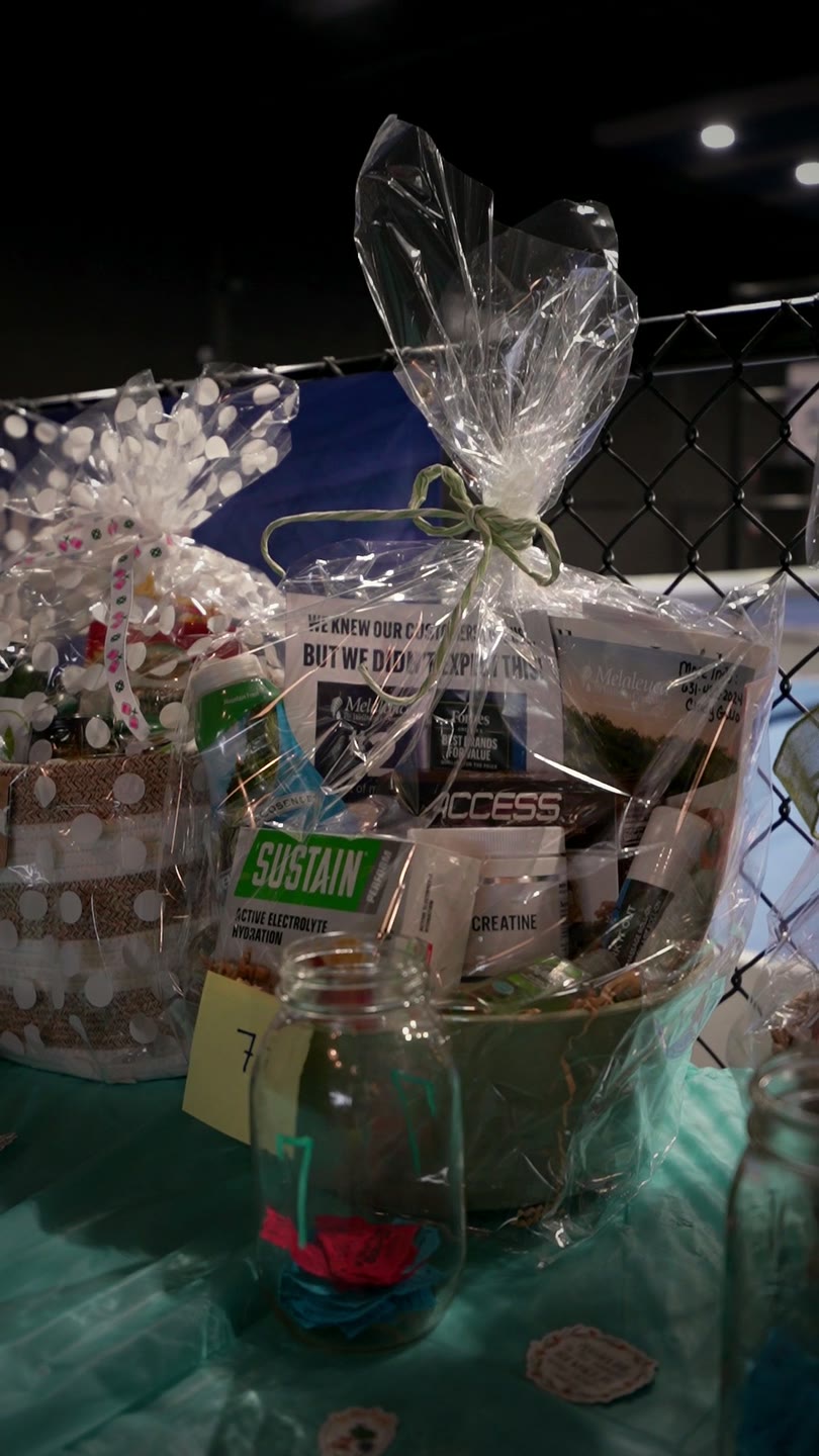 Raffle baskets wrapped in cellophane on the basket auction table at Connect Church's Pickleball Day at The Picklr